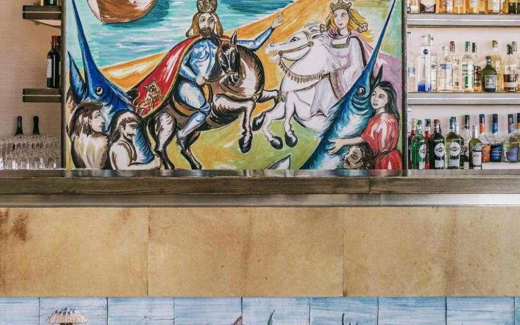 Bancone bar decorato con dipinto raffigurante figure a cavallo e bottiglie di liquori