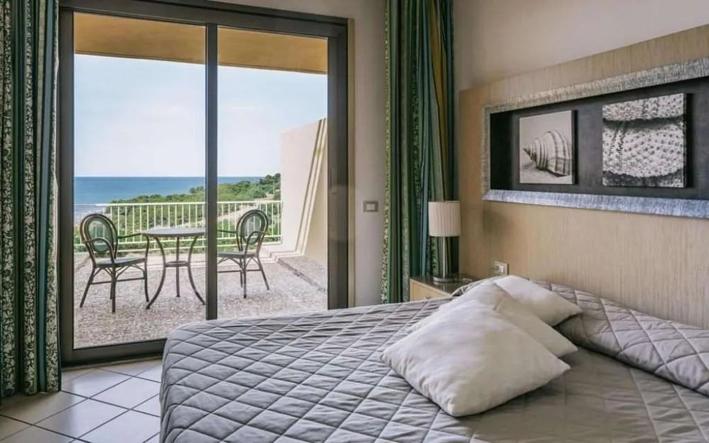 Camera matrimoniale con balcone e vista sul mare e sulla vegetazione