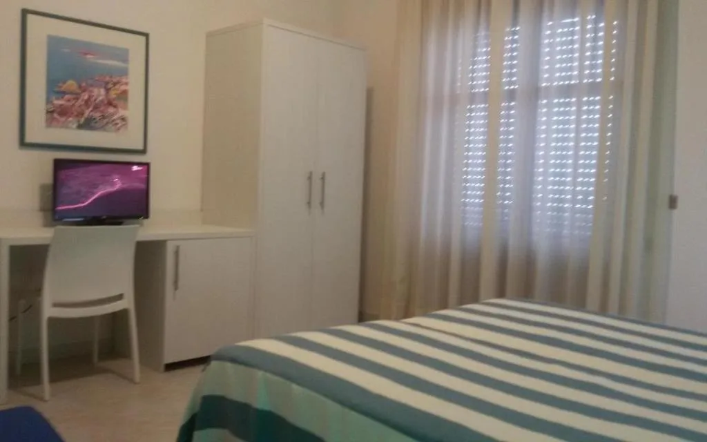 Camera luminosa con scrivania, TV e letto a righe