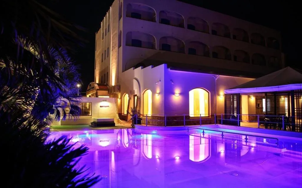 Piscina dell'hotel illuminata di viola in notturna