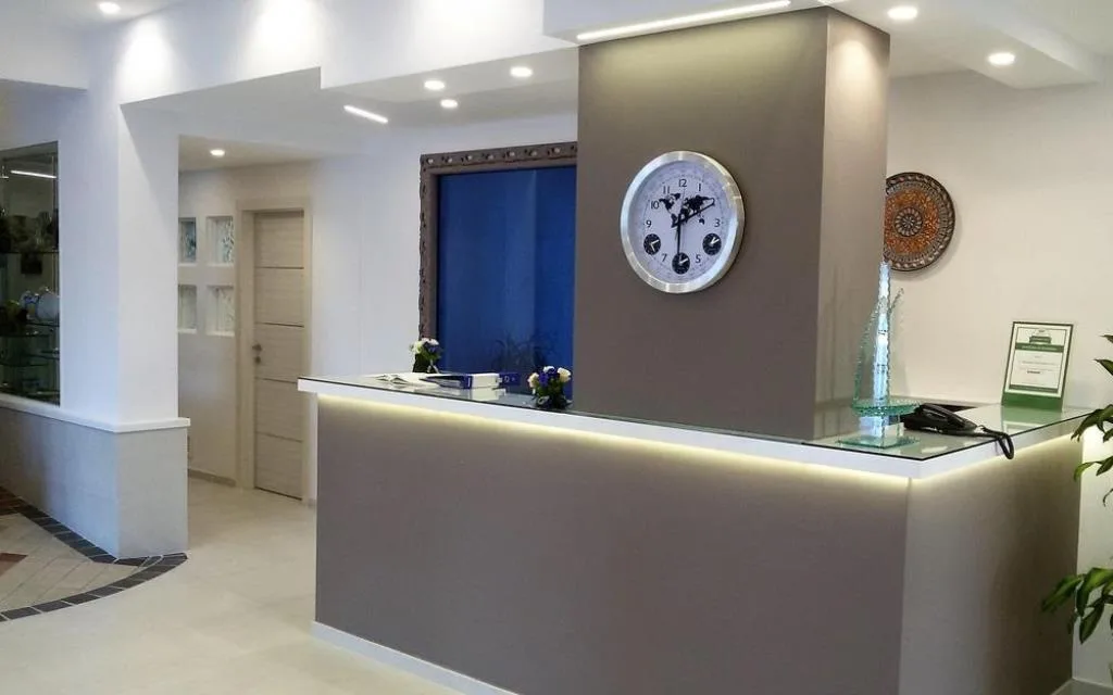 Reception dell'hotel con bancone moderno e orologio a parete