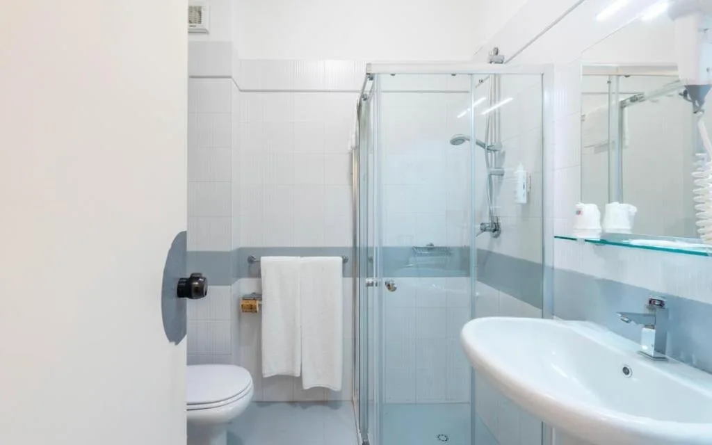 Bagno con doccia, lavabo, WC e finiture bianche e azzurre