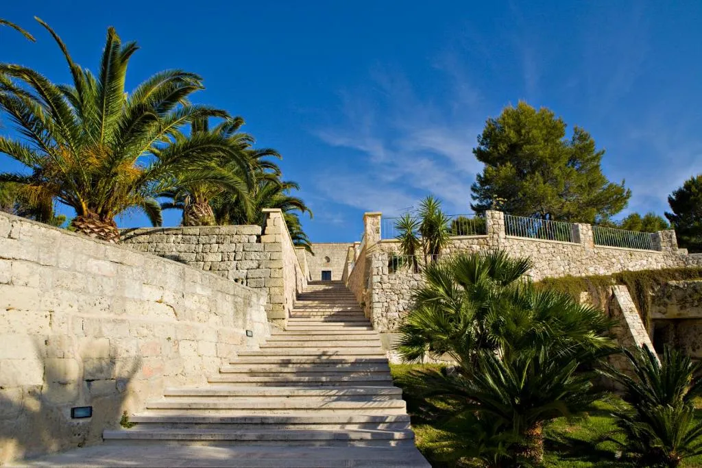 Scalinata in pietra circondata da palme e vegetazione mediterranea