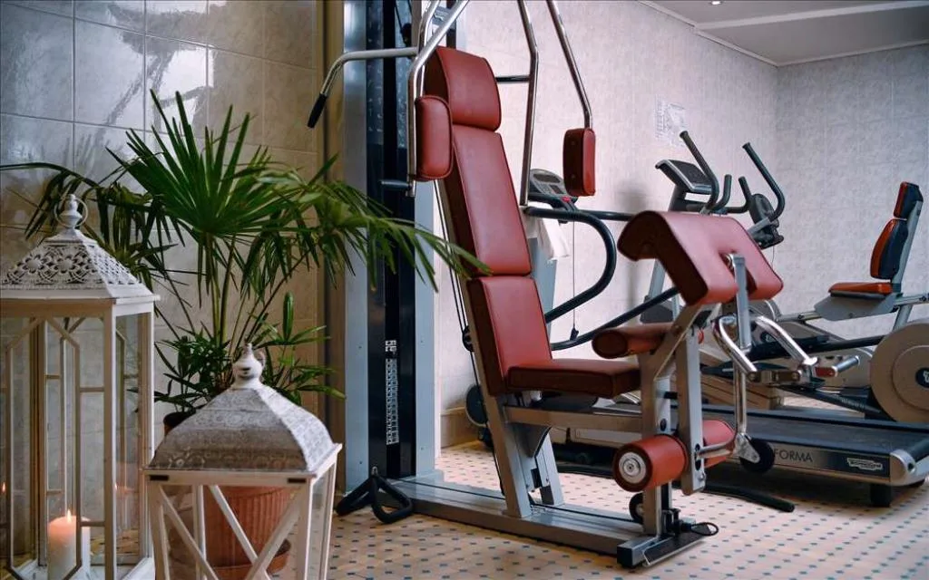 Sala fitness con macchinari per esercizi e piante decorative