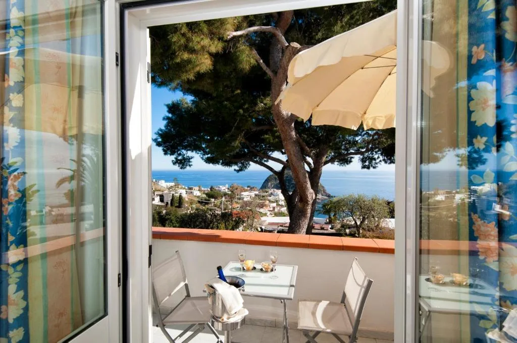 Vista sul mare e sul borgo da una camera con balcone e ombrellone