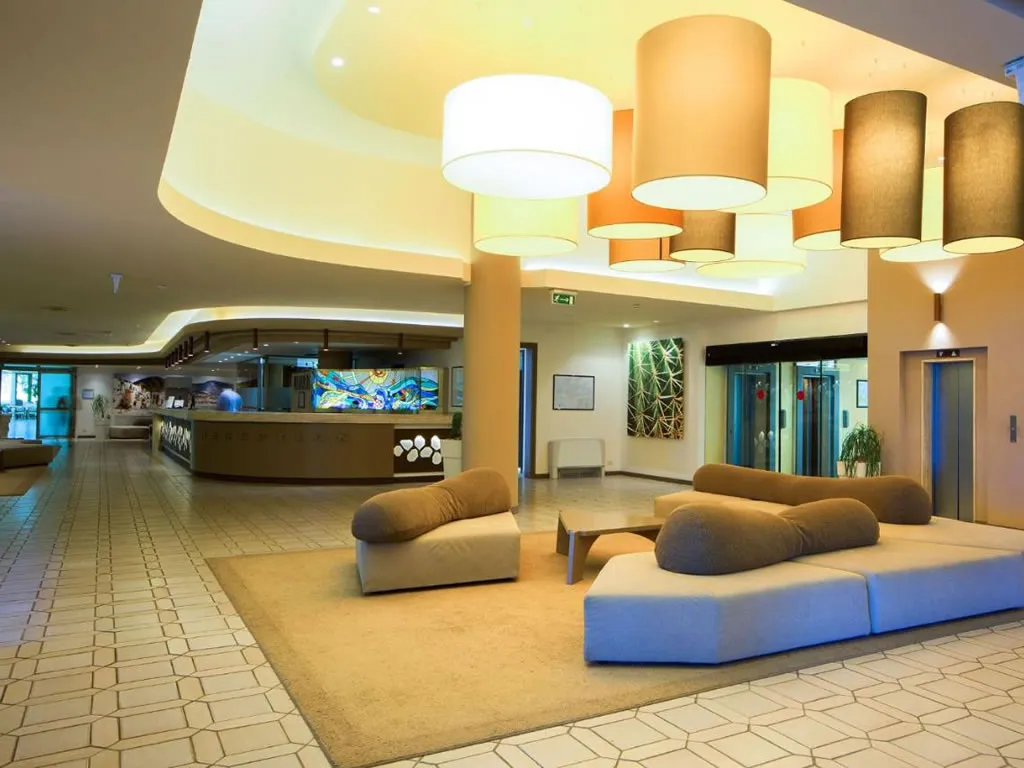Lobby moderna con divani morbidi, lampade a sospensione e reception