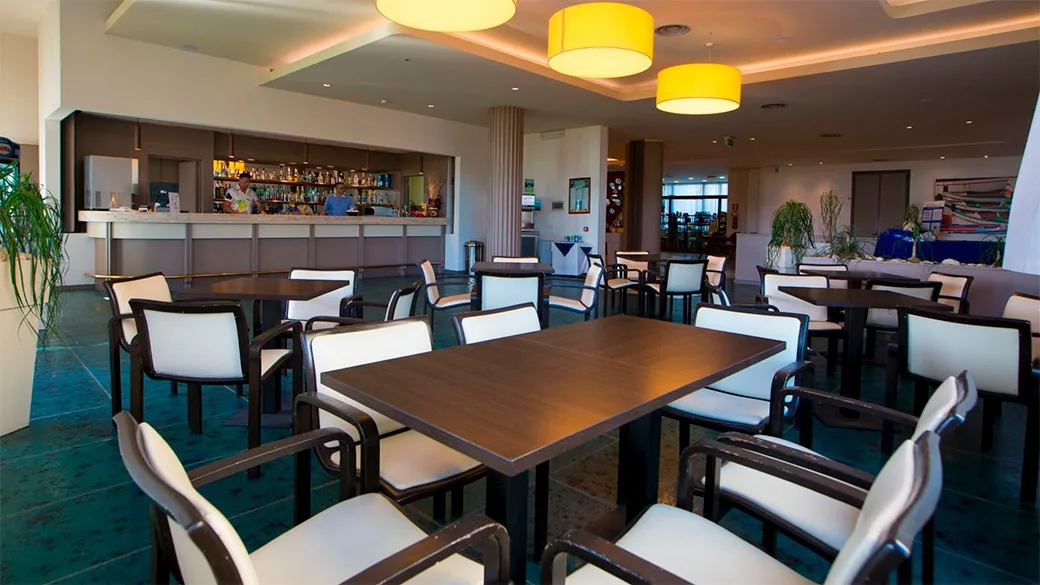 Area bar interna con tavoli, sedie e bancone