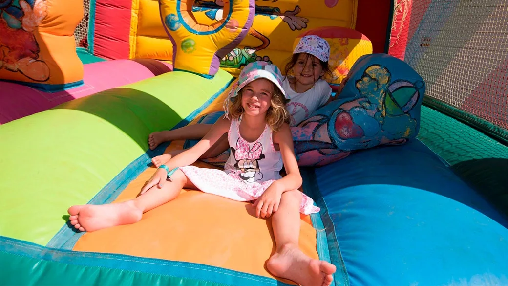 Bambine sorridenti su gonfiabile colorato per giochi all'aperto