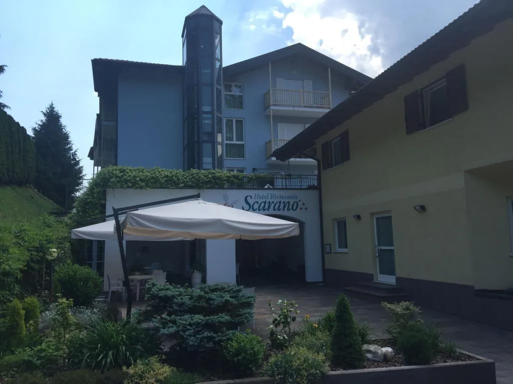 Ingresso dell'Hotel Ristorante Scarano con gazebo bianco, giardino curato e vegetazione