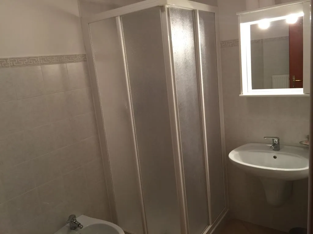 Bagno con cabina doccia, lavabo, bidet e specchio illuminato