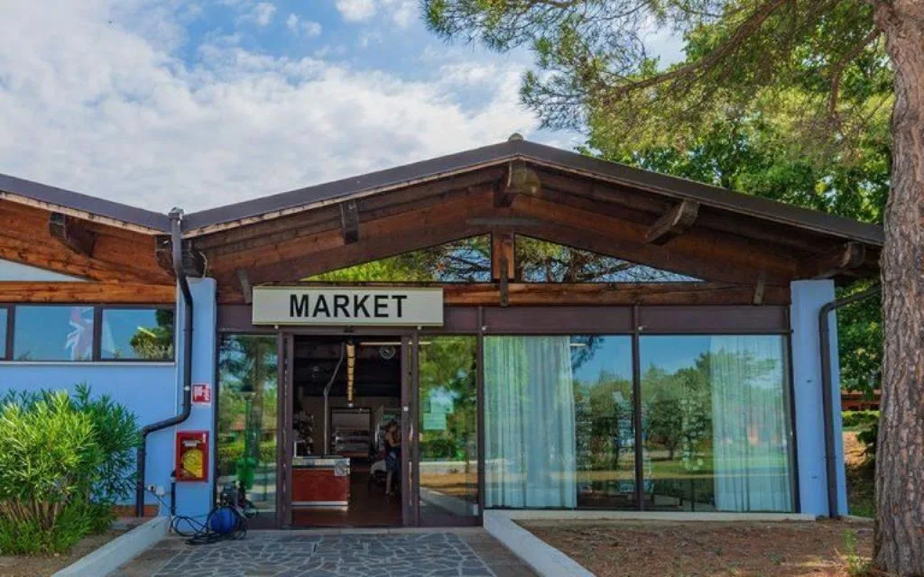 Ingresso del market del villaggio con struttura in legno e alberi