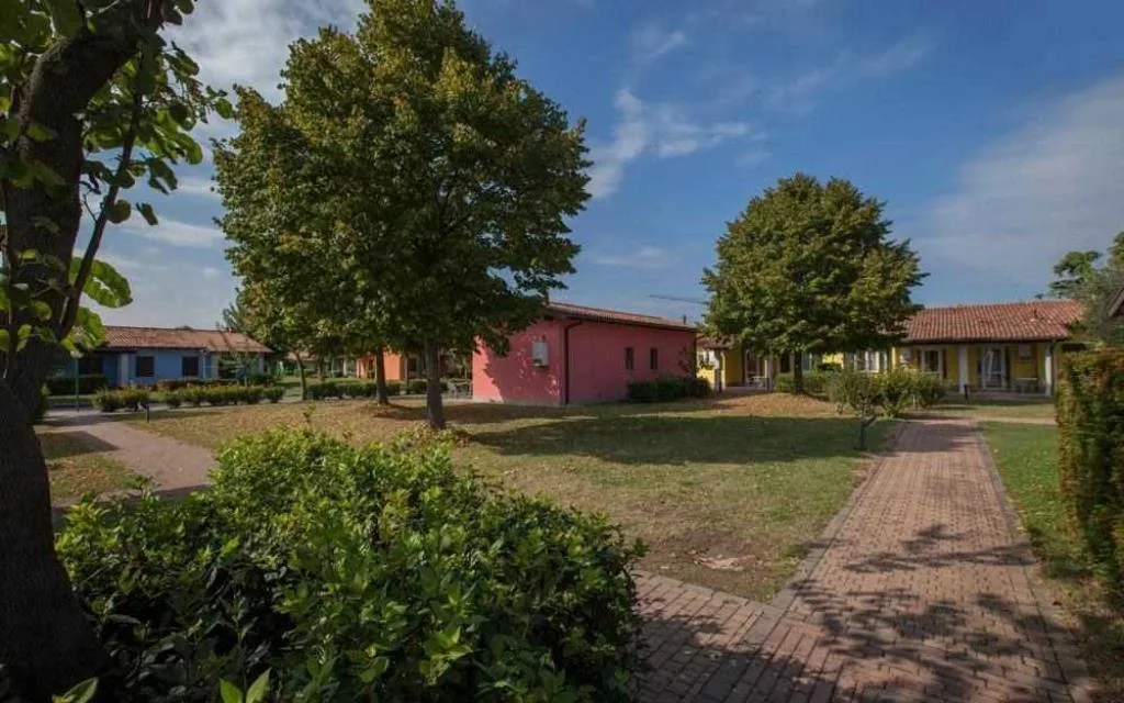 Villette colorate immerse nel verde con alberi e vialetti pedonali